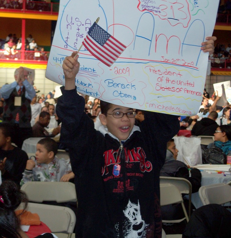 A student stands and cheers while watching the inauguration speeches which were broadcast at the Harlem Armory in New York City.